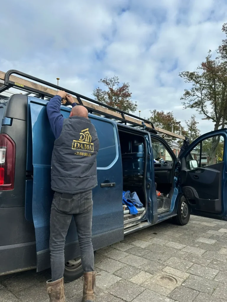 Medewerker bij een bedrijfsbus met imperiaal en geopende zijdeur in Barneveld