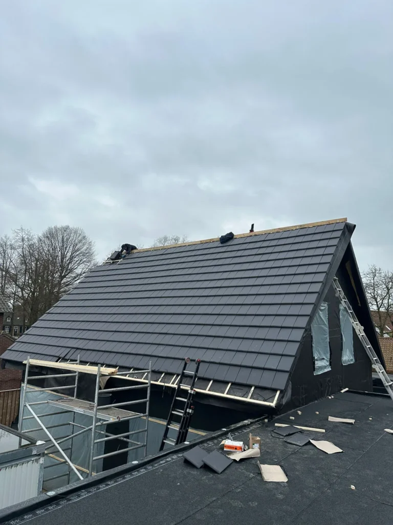 Nieuw antraciet pannendak op een woning met zwarte houten gevel in Kootwijkerbroek