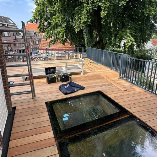Dakterras met houten vlonder, glazen daklichten en metalen hekwerk in Lunteren