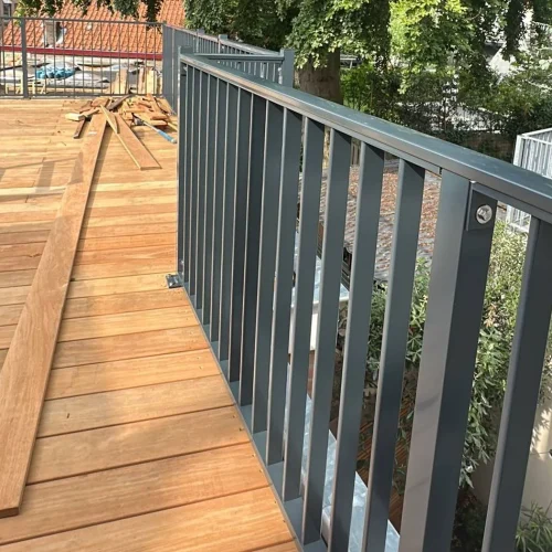 Hardhouten vlonderdelen en grijs hekwerk op een dakterras in Lunteren