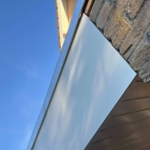 Gladde dakrandbekleding met strakke aluminium afwerking langs een gevel in Wekerom