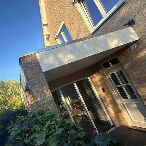 Aanbouw met nieuwe witte boeidelen boven de tuindeuren in Wekerom
